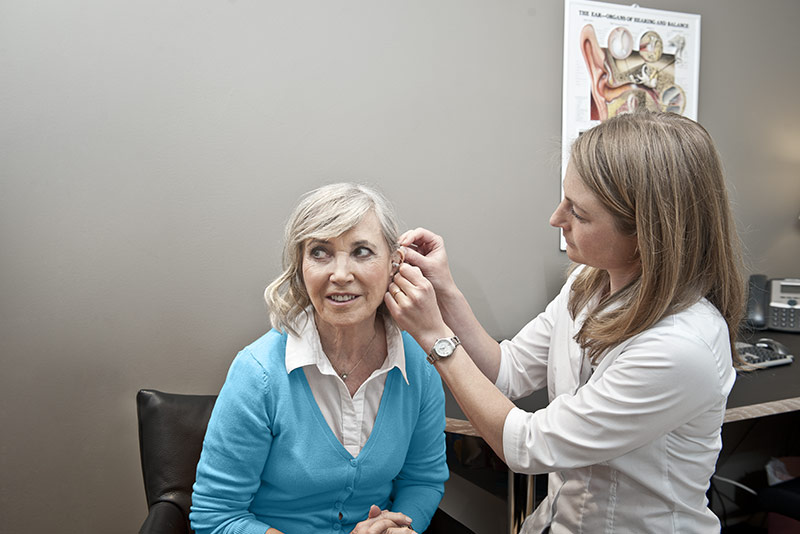 Woman having a hearing aid fitted in a hearing clinic